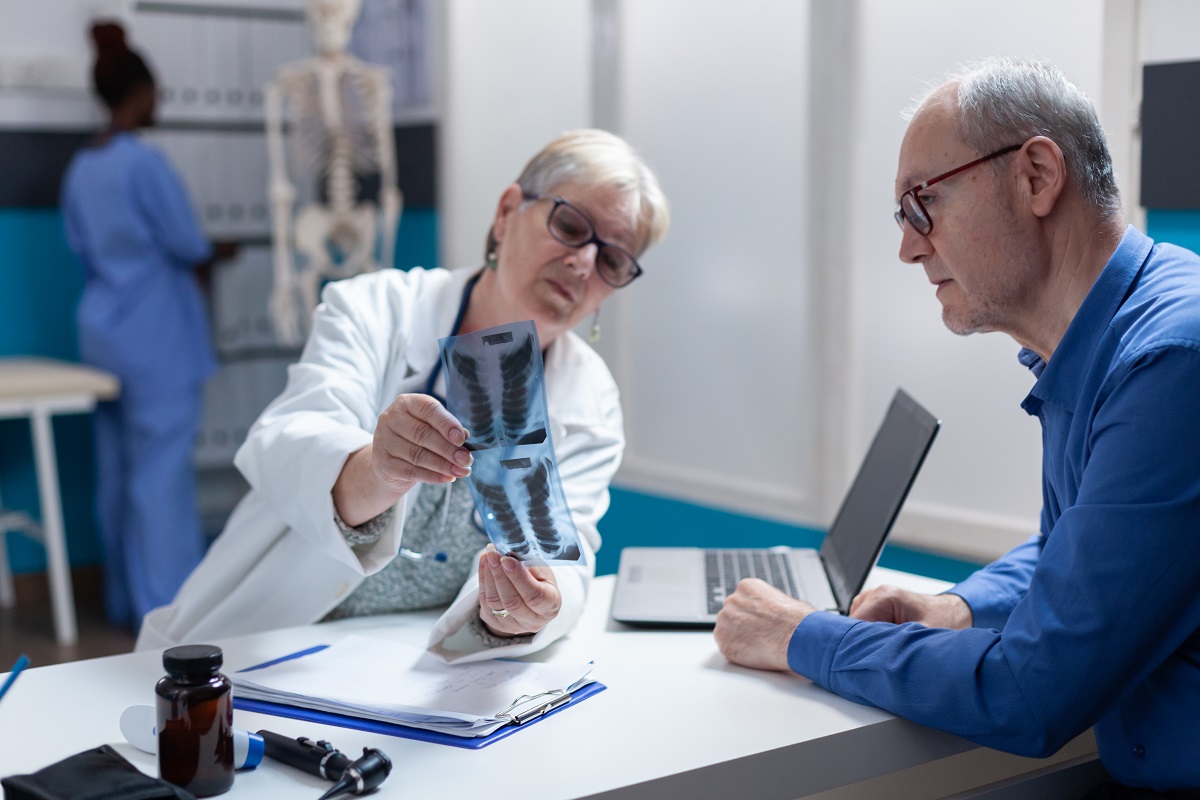 médica e paciente analisam exame de raio-x